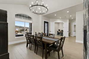 Dining area with an inviting chandelier, vaulted ceiling, and light hardwood / wood-style floors