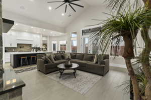 Living room featuring ceiling fan, sink, high vaulted ceiling, and light hardwood / wood-style flooring