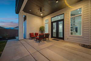 Patio terrace at dusk featuring an outdoor hangout area, ceiling fan, and french doors