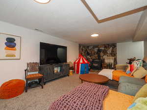 Living room with carpet flooring and a wood stove