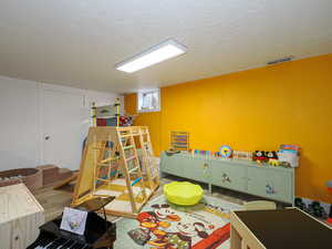 Game room with hardwood / wood-style flooring and a textured ceiling