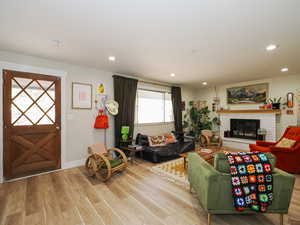 Living room with light wood-type flooring and a fireplace