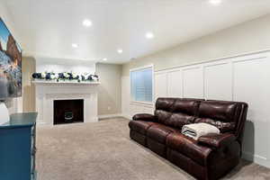 Living room featuring a brick fireplace and light colored carpet