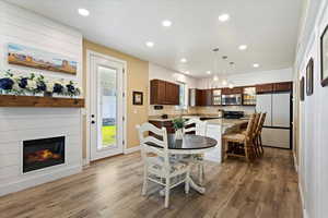 Kitchen with hanging light fixtures, fridge, hardwood / wood-style floors, and a kitchen island