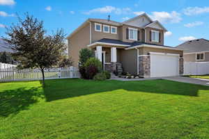 View of front of house with a garage and a front yard