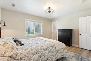 Bedroom with hardwood / wood-style floors and a textured ceiling