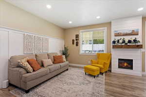 Living room featuring a large fireplace and light wood-type flooring