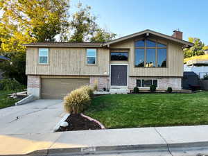 View of front of property featuring a garage and a front yard