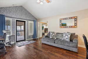 Living room featuring lofted ceiling, hardwood / wood-style floors, and ceiling fan