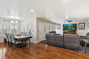 Interior space with dark hardwood / wood-style floors and ceiling fan with notable chandelier