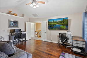 Office featuring vaulted ceiling, dark wood-type flooring, and ceiling fan