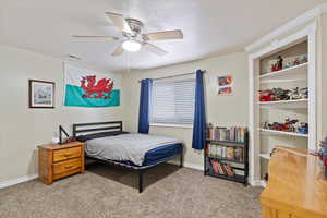 Bedroom with ceiling fan and light carpet