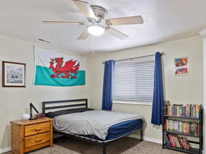 Bedroom with ceiling fan and light carpet