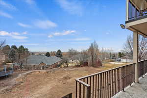 View of yard with a balcony and a trampoline