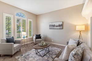 Carpeted living area featuring baseboards
