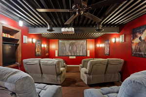 Home theater with carpet floors and ceiling fan