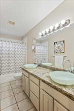 Full bathroom featuring shower / tub combo, tile patterned flooring, vanity, a textured ceiling, and toilet