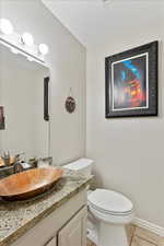 Bathroom featuring vanity, tile patterned floors, and toilet