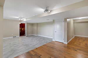 Finished below grade area featuring light wood-type flooring and baseboards