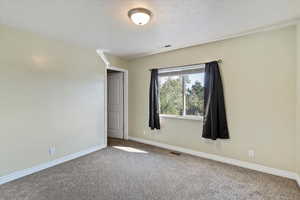 Empty room featuring baseboards and carpet