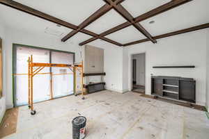 Unfurnished living room featuring coffered ceiling and beam ceiling