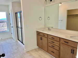 NOT exact home MODEL OF same florrplan Bathroom with vanity, tile patterned flooring, and a shower with door