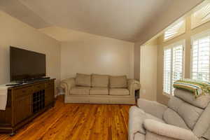 Living room featuring hardwood / wood-style flooring and vaulted ceiling