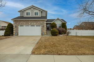 View of front of home with a garage and a front lawn