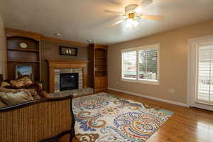 Living room with ceiling fan, light hardwood / wood-style floors, and a textured ceiling