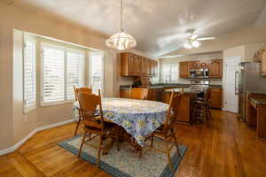 Dining area featuring dark hardwood / wood-style flooring, sink, vaulted ceiling, and ceiling fan