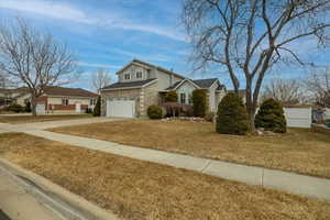 View of front of house with a garage and a front lawn