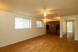 Family room with hardwood / wood-style flooring, ceiling fan, and a textured ceiling