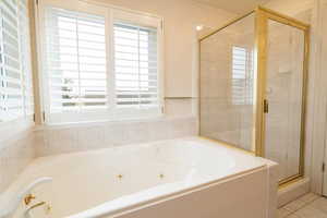 Primary Bathroom with tile patterned flooring and independent shower and bath