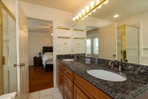 Primary Bathroom featuring an enclosed shower, vanity, and tile patterned floors