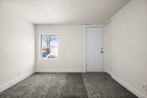 Carpeted empty room with a textured ceiling