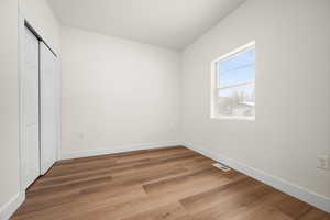 Unfurnished bedroom featuring hardwood / wood-style floors and a closet