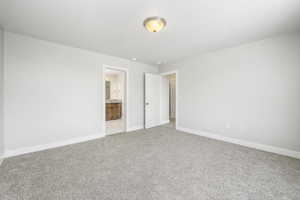 Unfurnished bedroom featuring ensuite bath and carpet floors