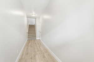 Corridor with light hardwood / wood-style flooring