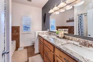 Full master bathroom with vanity, tile patterned floors, shower and separate jetted tub