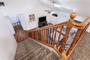 Stairs with ceiling fan and lofted ceiling