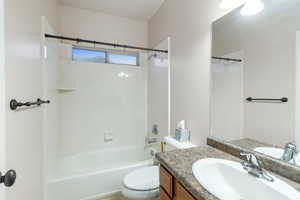 Full bathroom with vanity, bathing tub / shower combination, and toilet