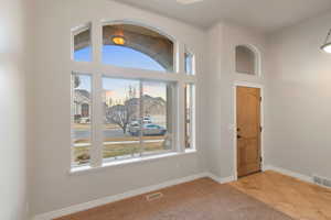 Entrance foyer with a high ceiling and carpet flooring