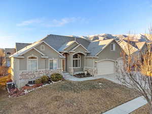 View of front of home featuring a garage, a front yard, and central air condition unit