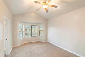 Spare room with vaulted ceiling, light colored carpet, and ceiling fan