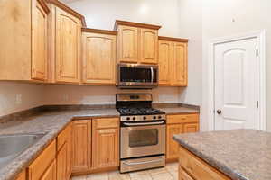 Kitchen with stainless steel appliances, sink, and light tile patterned floors