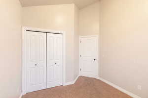 Unfurnished bedroom with carpet flooring and a closet