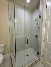 Bathroom with a shower with shower door and toilet