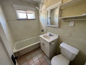 Full bathroom with tile patterned flooring, vanity, shower / tub combination, and toilet