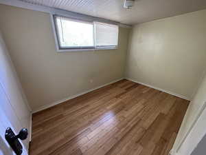 Unfurnished room with wood ceiling and hardwood / wood-style floors