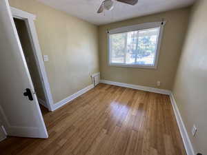 Unfurnished room featuring ceiling fan, a textured ceiling, and light wood-type flooring